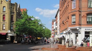 A public square with a fountain, surrounded by historic buildings with shops and cafes. - Quite, artsy apartment in a central location (Hannover)