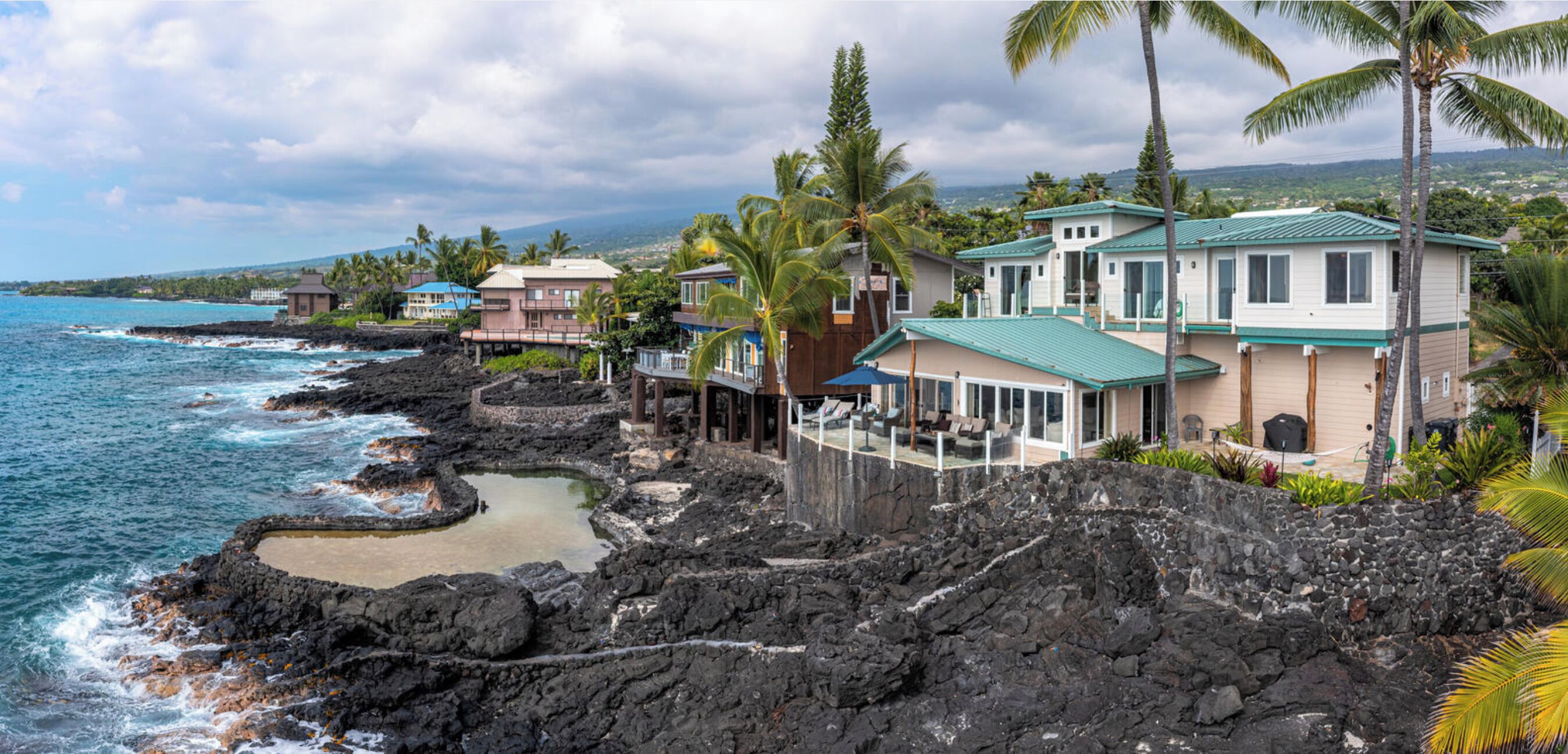 Une propriété située sur la côte, comprenant plusieurs maisons, un littoral rocheux et offrant une vue sur l’océan.