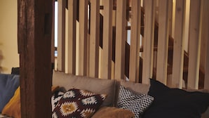 Un letto in legno rustico con materasso, cuscini e coperta.
