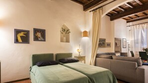 A room with two single beds, a sofa, a small table, and a lamp. - Pitti Studio by Mmega (Florence)