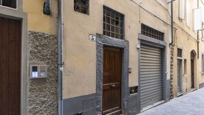 A building with a wooden door, a window with bars, and a garage door. - Pitti Studio by Mmega (Florence)