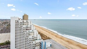 Ein Hochhaus-Hotel mit mehreren Balkonen mit Blick auf Strand und Meer.
