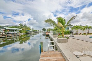 Guests can enjoy a serene waterfront setting with a canal, lush greenery, and a dock.