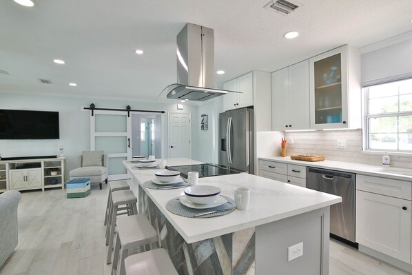 Enjoy cooking in this well-equipped kitchen with a central island and stove, perfect for preparing meals.