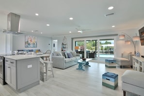 Relax in this open-plan living space with an island, dining table, and comfortable seating area.