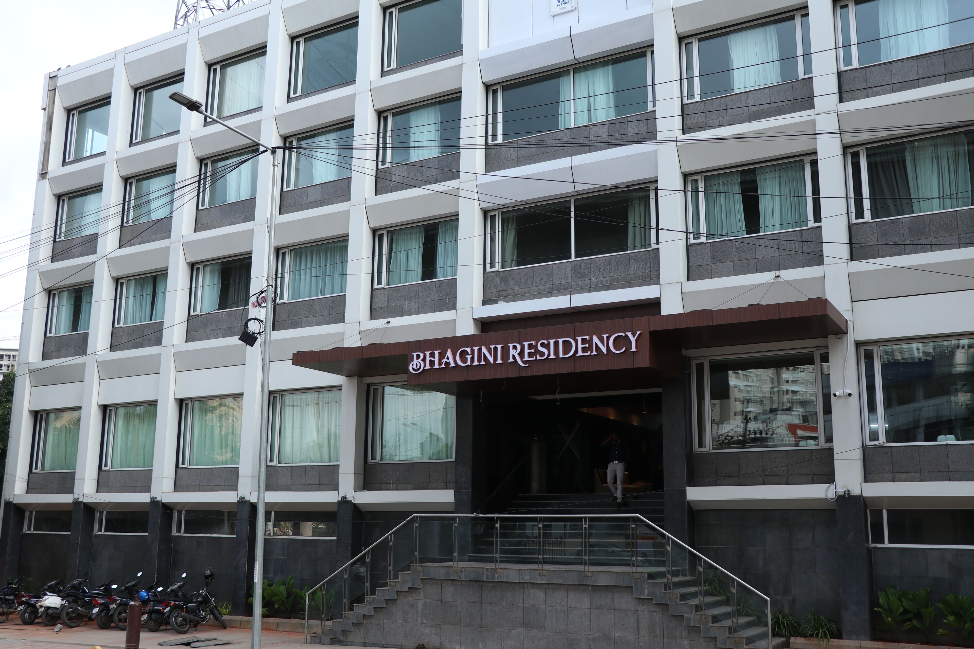 A multi-story building with a sign reading "BHAGINI RESIDENCY."