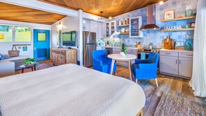 Eine moderne Küche mit einem Edelstahl-Kühlschrank, einem Essbereich mit blauen Stühlen und einer Holzbeschreibung.
