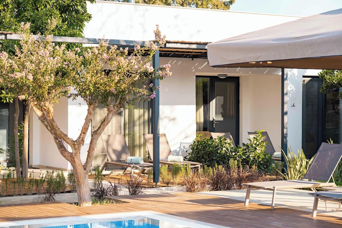 A modern outdoor pool area with lounge chairs and a pergola.