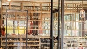 A wine cellar with shelves of wine bottles and glasses.