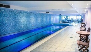 Relax by the pool surrounded by a mosaic of blue tiles and comfortable seating.