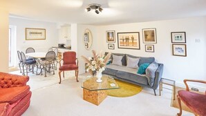 A living room with a sofa, armchairs, a coffee table, and a dining area with chairs and a table. - Host & Stay | Rose Cottage (Middlesbrough)