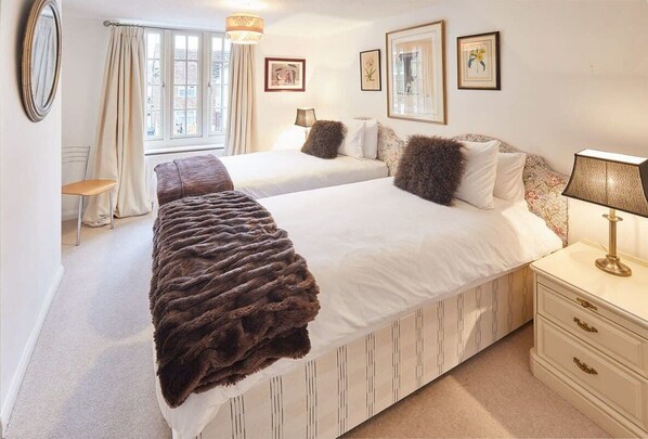 A double bed with a fluffy blanket, a bedside table with a lamp, and a window with curtains. - Host & Stay | Rose Cottage (Middlesbrough)