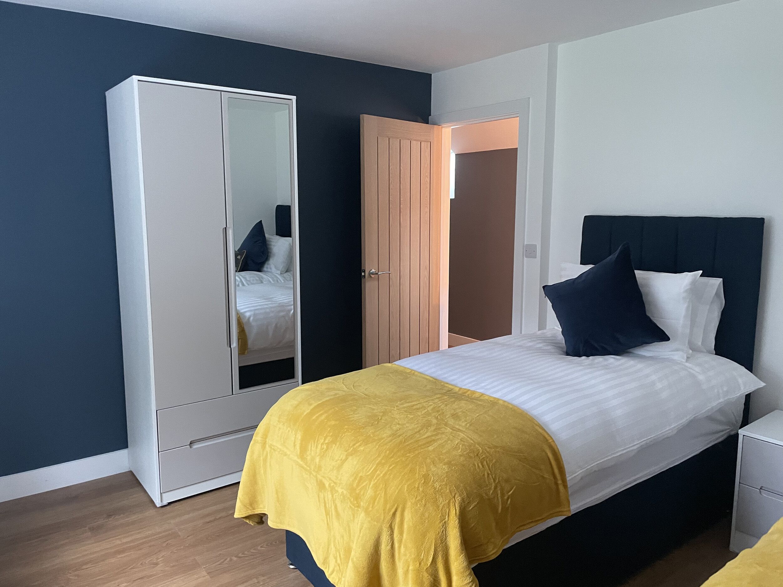 Une chambre à coucher avec un lit, une armoire et une porte.