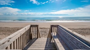 A wooden boardwalk leading to a beach with a clear view of the ocean and a partly cloudy sky. - Shore Thing | Oceanfront + Private Beach Access! (Surf City)