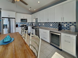 A modern kitchen with white cabinets, a microwave, a stove, and a dishwasher.