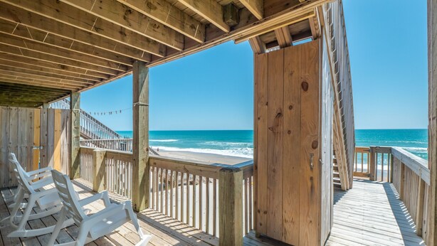 A wooden deck with white rocking chairs overlooking a beach. - Shore Thing | Oceanfront + Private Beach Access! (Surf City)