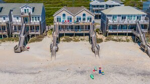 A beachfront property with multiple decks, a sandy beach, and a view of the ocean. - Shore Thing | Oceanfront + Private Beach Access! (Surf City)