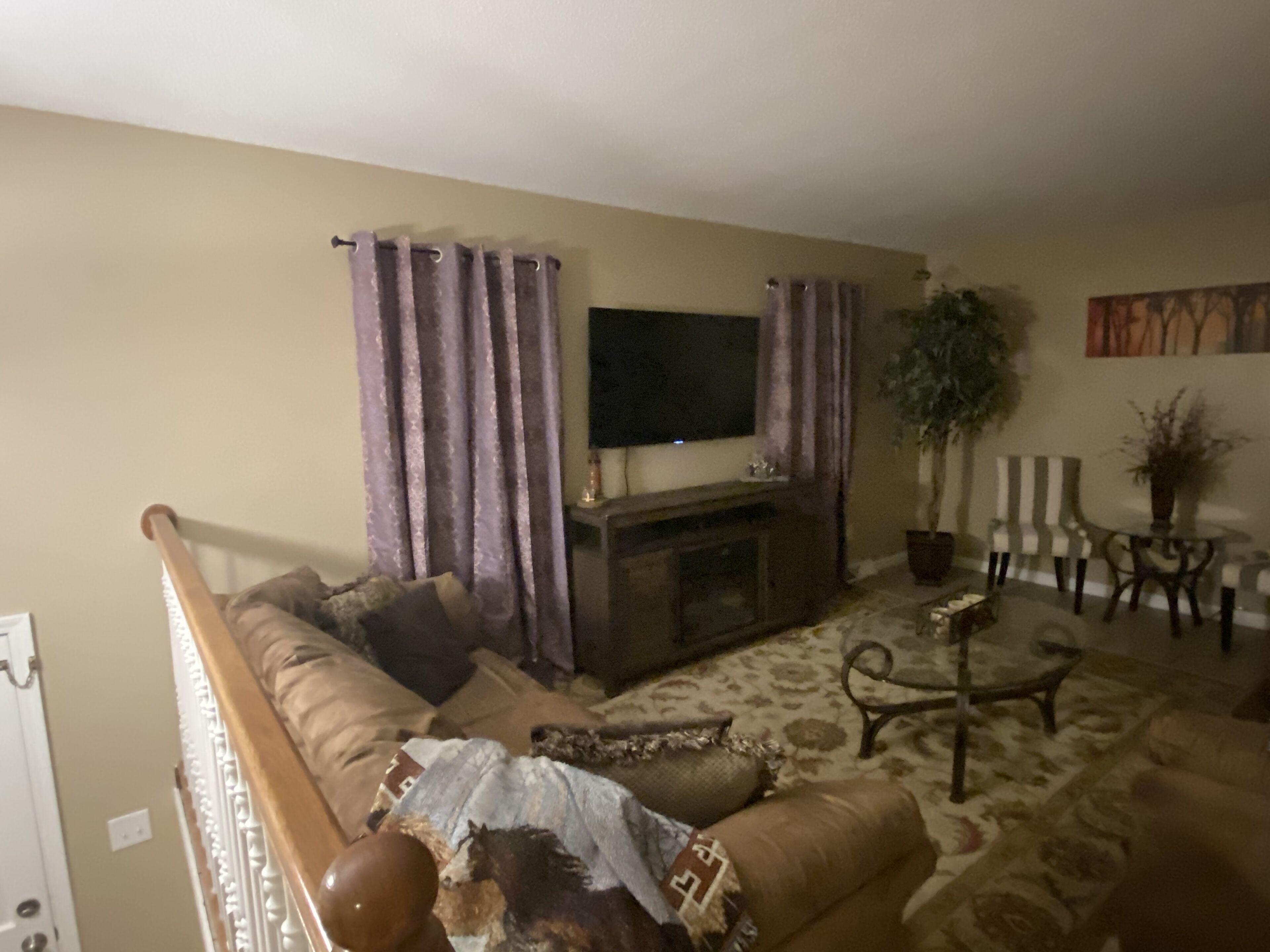 A living room with a sofa, a coffee table, a fireplace, and a television.