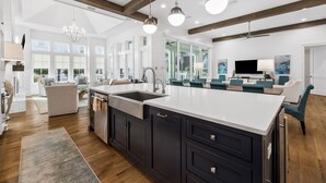 A spacious kitchen with a large island, dark cabinetry, and pendant lighting. - Seagrove Sparrow|Easy Beach Access|Private Pool|Outdoor Oasis (Santa Rosa Beach)