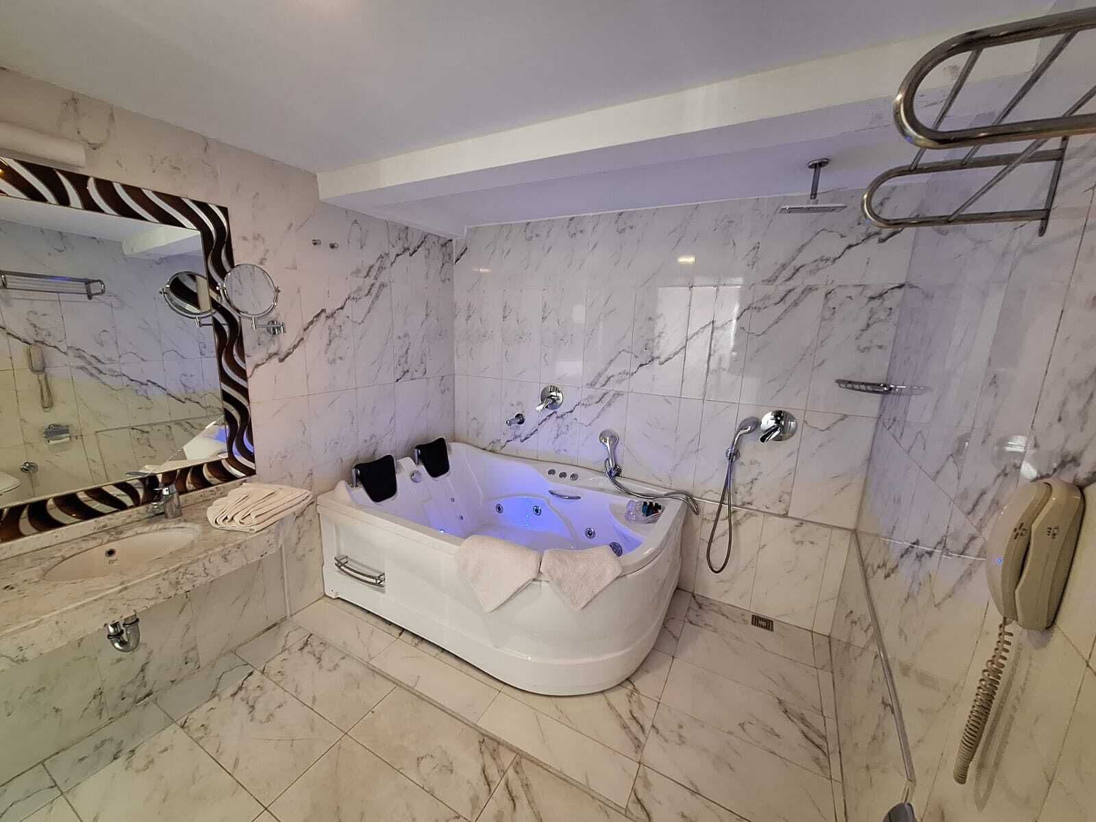A modern bathroom with a freestanding bathtub, a vanity with a mirror, and a shower area.