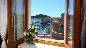 Una ventana con vista a un puerto, barcos y edificios históricos.