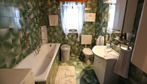 Ein Badezimmer mit Badewanne, Toilette, Waschbecken und Dusche.