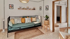 A cozy living room with a sofa, a hanging light fixture, a small table with a plant, and a doorway leading to another room. - Algarve house, sun, terrace, views and barbecue (Silves)