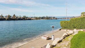 Une propriété située au bord de l’eau, dotée d’une terrasse, d’un lampadaire et offrant une vue sur l’eau et les montagnes.