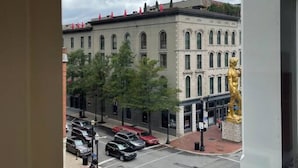 A view of a street with a building featuring arched windows and a statue of a figure. - Lou-City Penthouse by Hollyhock Suites (Louisville)
