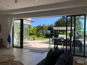 Una sala moderna con un amplio ventanal corredero que da a un patio exterior.