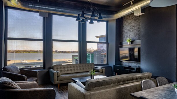 Een moderne lounge met grote ramen, een open haard en comfortabele zitplaatsen.