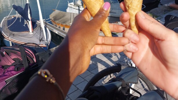Two ice cream cones held by hands, with a marina and boats in the background. - Apartment T3 ❤de ville. (La Rochelle)