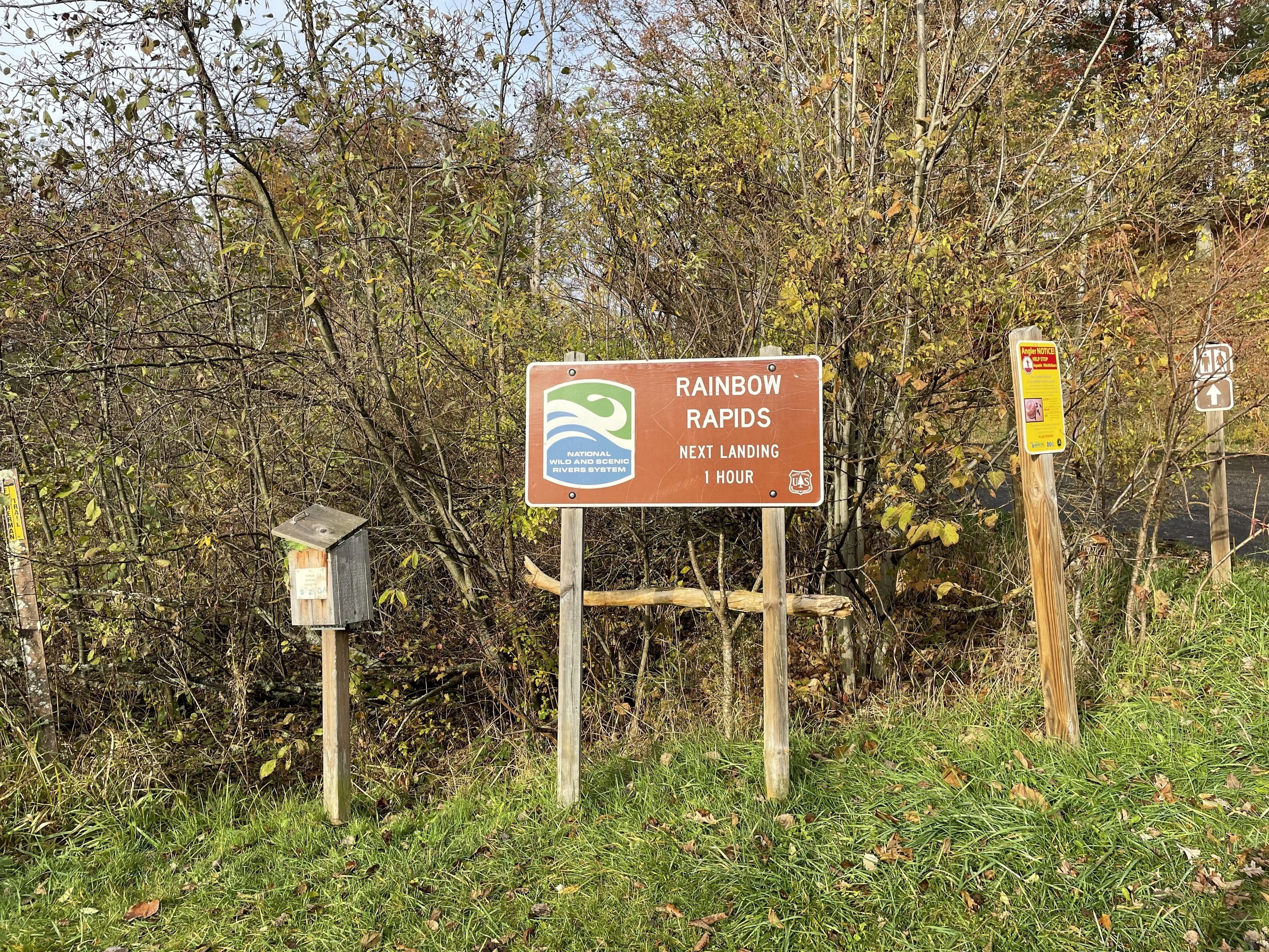 A sign for Rainbow Rapids with a logo and text indicating the next landing is in 1 hour.