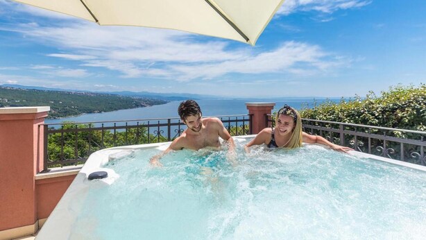 Un jacuzzi con vistas panorámicas a un lago y montañas.