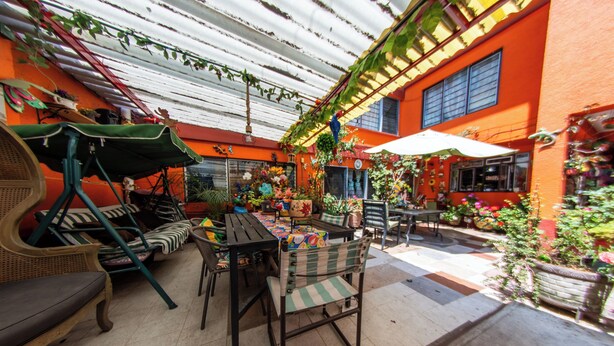 Une terrasse extérieure avec une table, des chaises et une balançoire.