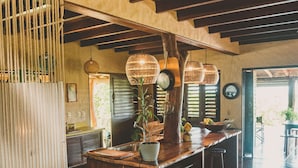 A spacious kitchen with wooden countertops, a central island, and hanging pendant lights.