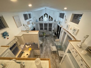 A corner of a room with a kitchen area, a dining table, and a seating area with a chandelier. - Enjoy this modern and cozy house in Key Largo Florida. (Key Largo)