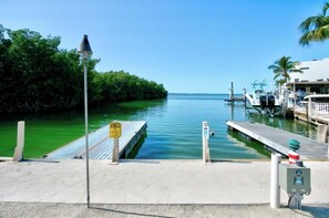 A marina with a dock extending into calm waters, surrounded by lush greenery. - Enjoy this modern and cozy house in Key Largo Florida. (Key Largo)