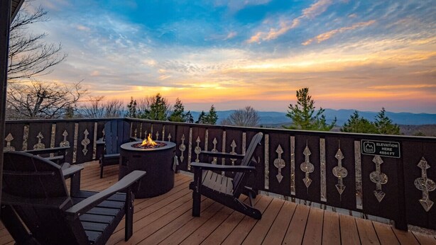 A deck with outdoor seating, a fire pit, and a view of the mountains at sunset. - Boho Chalet w/ Mountain Views (Beech Mountain)