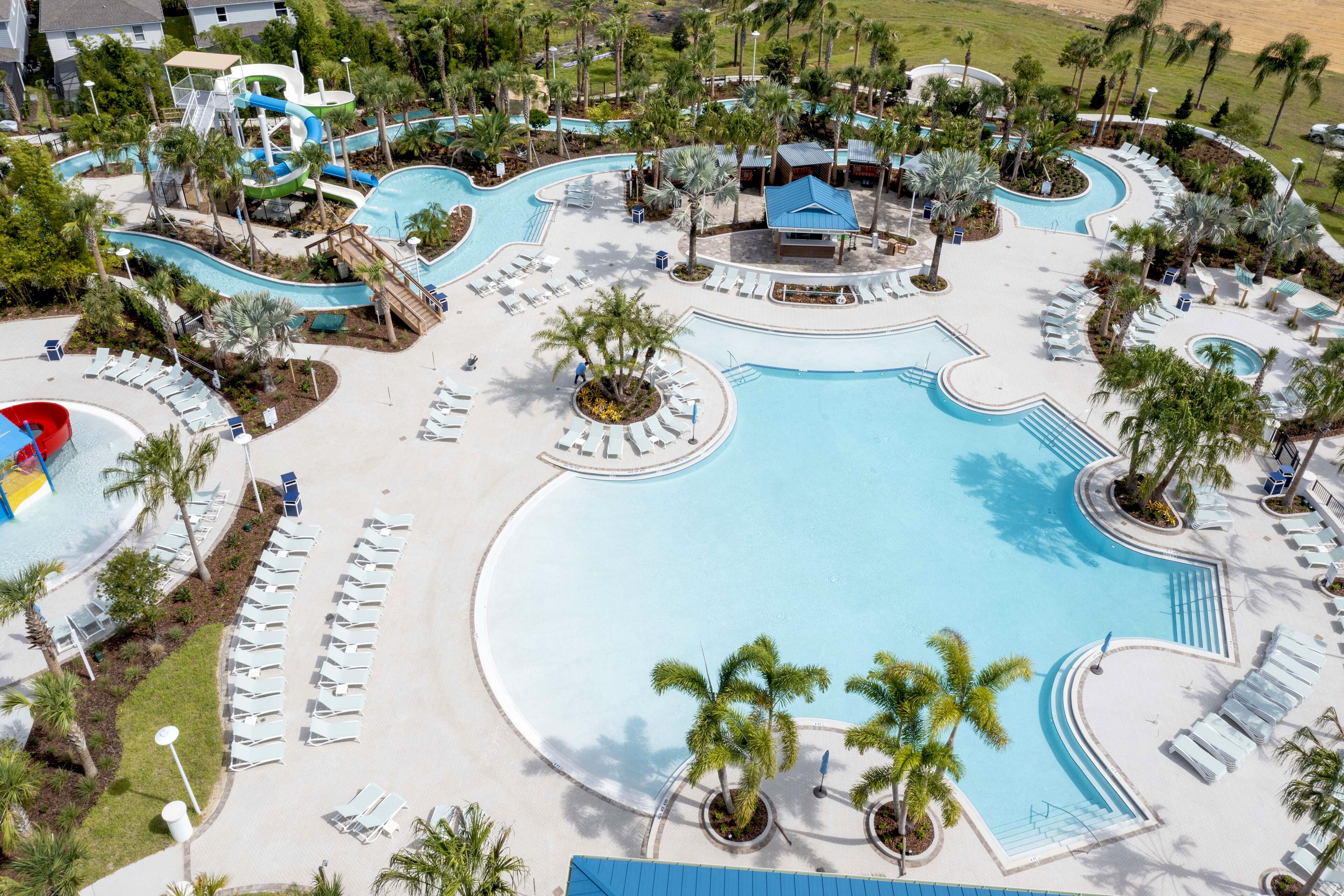 A resort with a large pool, multiple water slides, and sun loungers.