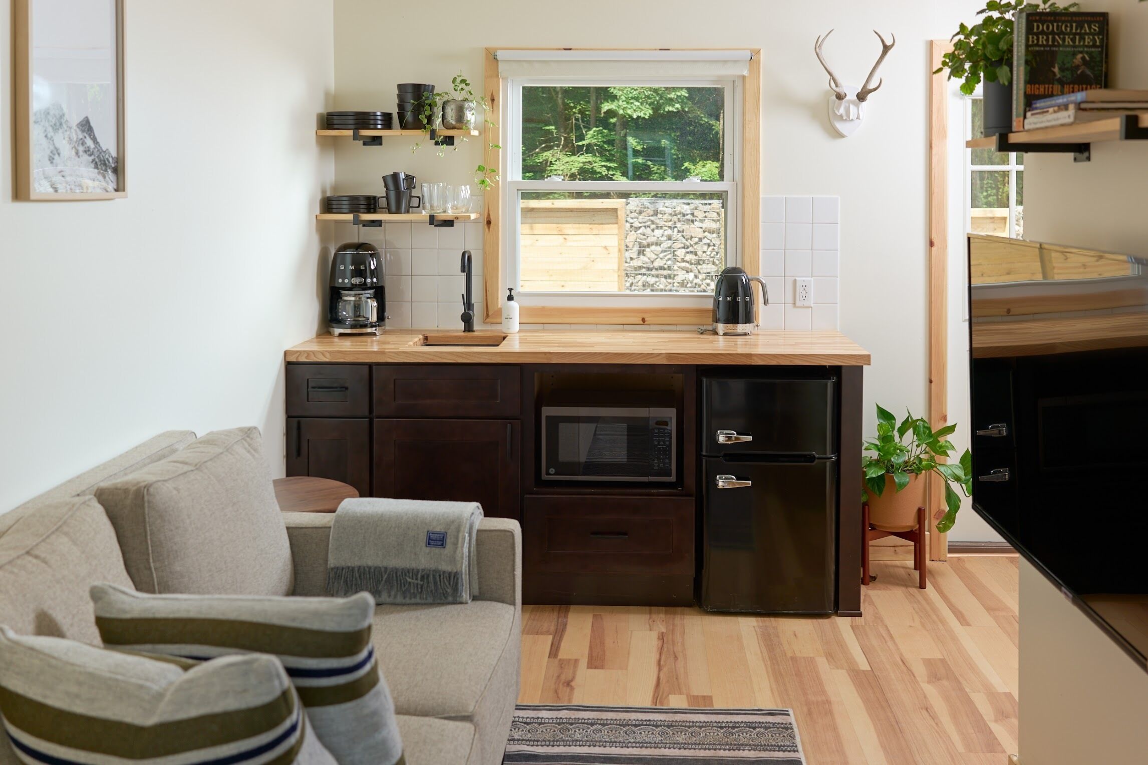 Una cocina compacta con encimera de madera, electrodomésticos integrados y vistas al exterior.