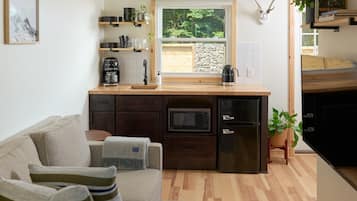 Una cocina compacta con encimera de madera, electrodomésticos integrados y vistas al exterior.
