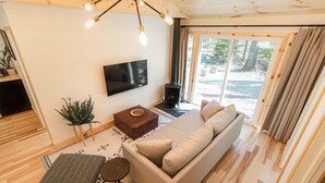 Una sala de estar acogedora con sofá, televisor, planta y chimenea.