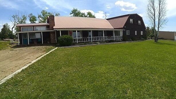 A two-story building with a covered porch and a fenced yard. - Sleeping Ute Micro Suite in beautiful SW Colorado (Dolores)