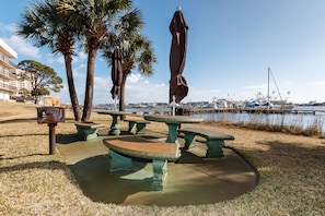 Enjoy waterfront dining or relaxation at this tranquil marina setting with picnic tables and a picturesque view.