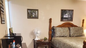 Un dormitorio con cama, mesita de noche, escritorio, silla y una mesa con juegos de mesa.