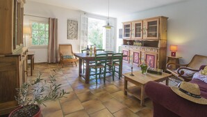 Een gezellige woonkamer met een eethoek, houten meubels en een potplant.