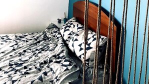 A bedroom with a bed, a wooden headboard, and a blue wall. - Studio with Lake View (București)