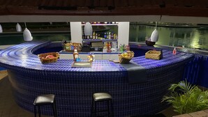 A circular bar area with a blue tiled floor, bar stools, and a counter with various bottles and a basket of fruits. - 1 Bedroom Penthouse Suite 63, Mystic Ridge Resort (Ocho Rios)