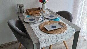 Una mesa de comedor dispuesta con platos, vasos y un florero.
